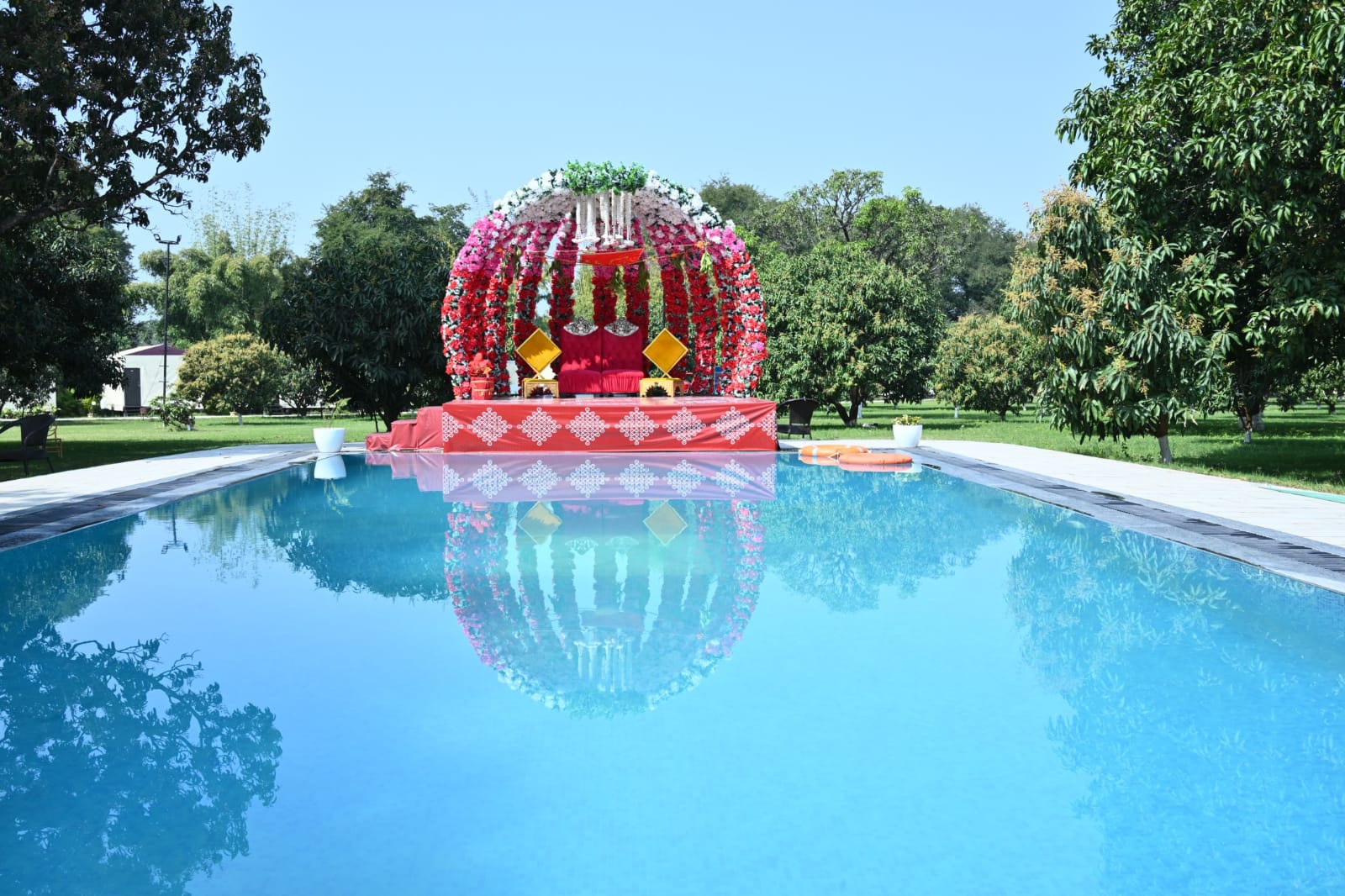 Floral wedding mandap beside the pool at Unwind Resort